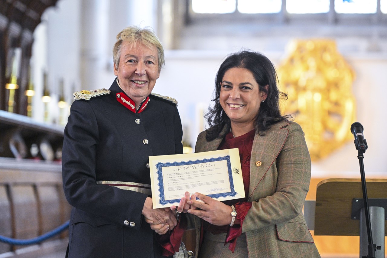Two women are smiling, holding a certificate.