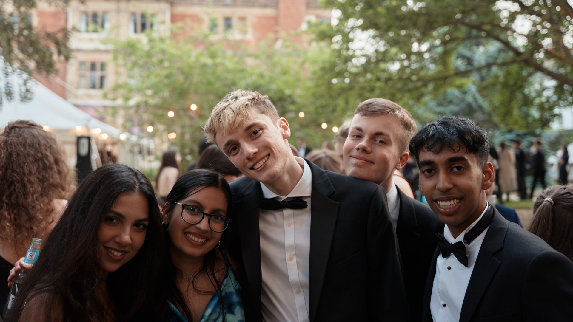 A small group of smartly dressed partygoers smile for the camera.