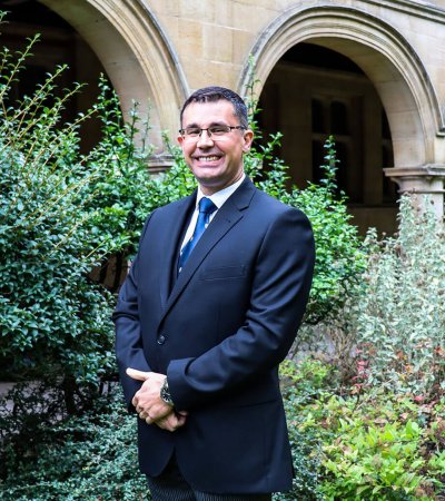 A photo of Head Porter Ian Whitwham standing in Cloister Court