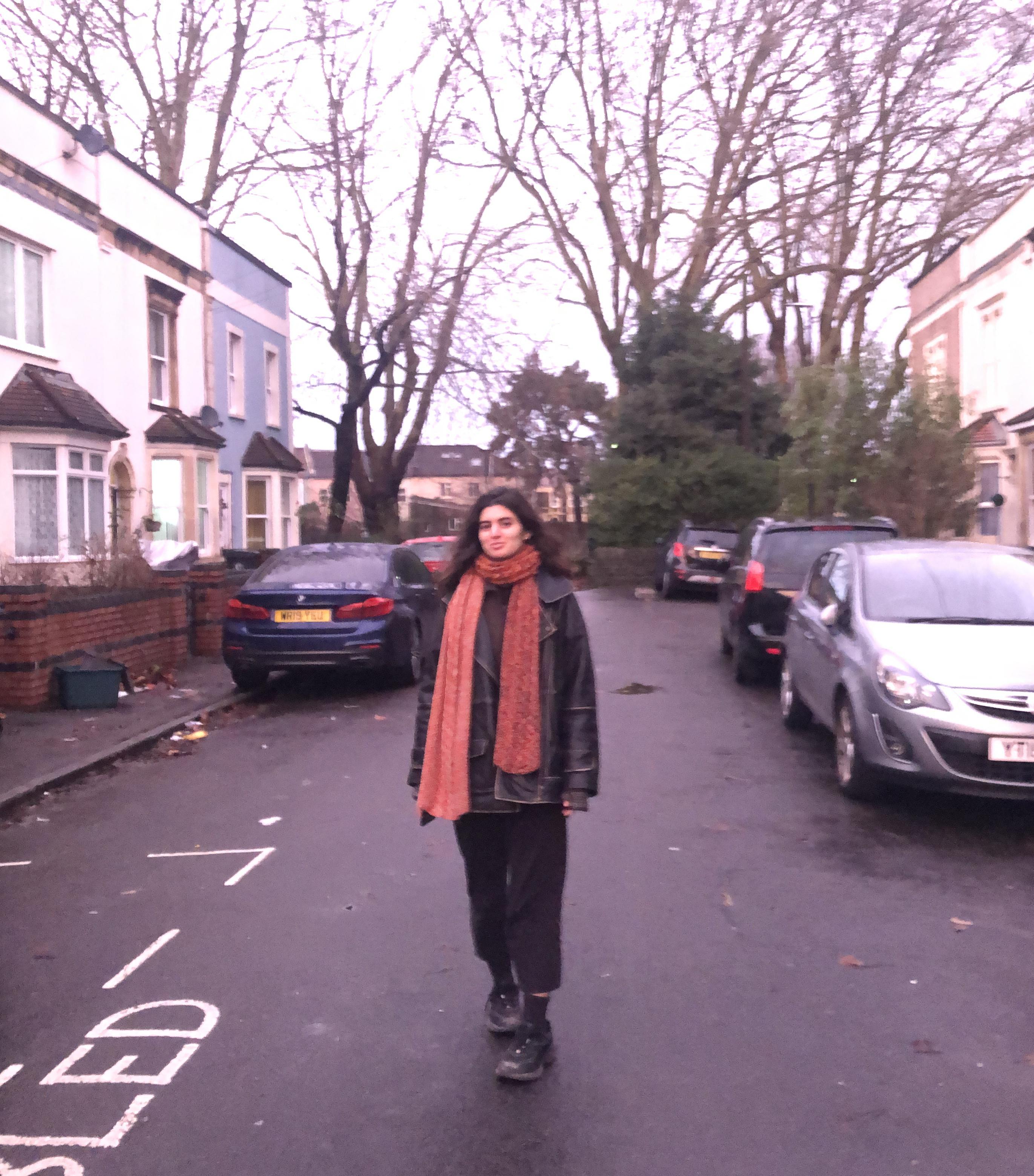 A woman stands in the middle of a suburban road